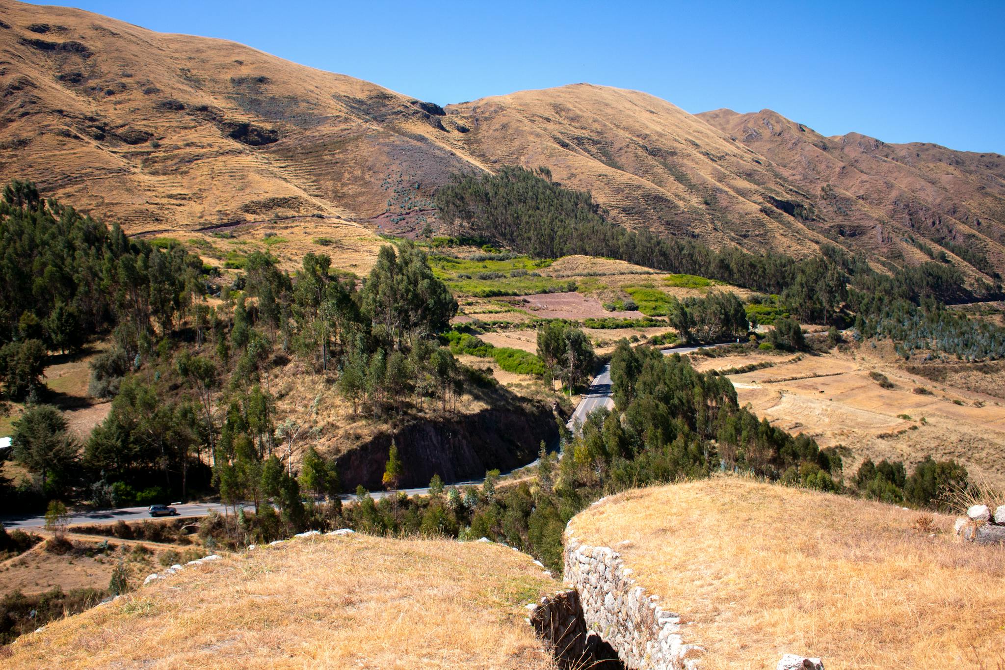 Explore the breathtaking Andes landscape near Cusco, featuring rolling hills and lush greenery.